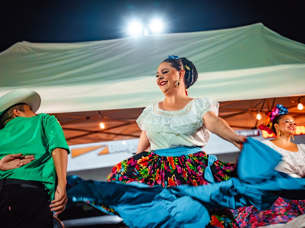 Folklorico dancer in a colorful skirt performing under tent lights