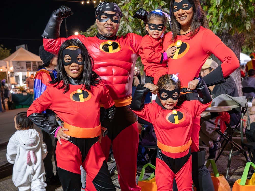 Family in matching superhero costumes at a Bonfire Event Co. night market