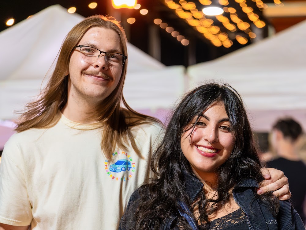 Two friends smiling at a Denver night market