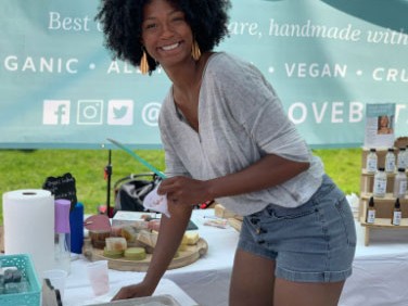 Vendor smiling at her booth at a Bonfire Event Co. market