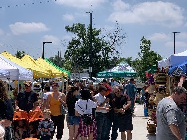 Market aisle with vendor tents and shoppers